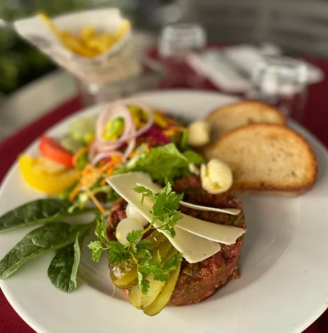 Tartare de bœuf aux copeaux de parmesan, pommes frites et toasts, salade et crudités