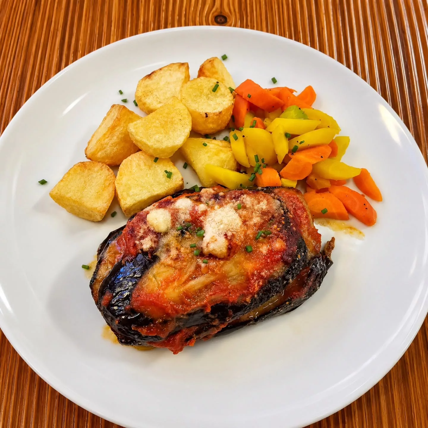 Millefeuilles d'aubergines, sauce tomate et parmesan, pommes de terre au four et carottes sautées