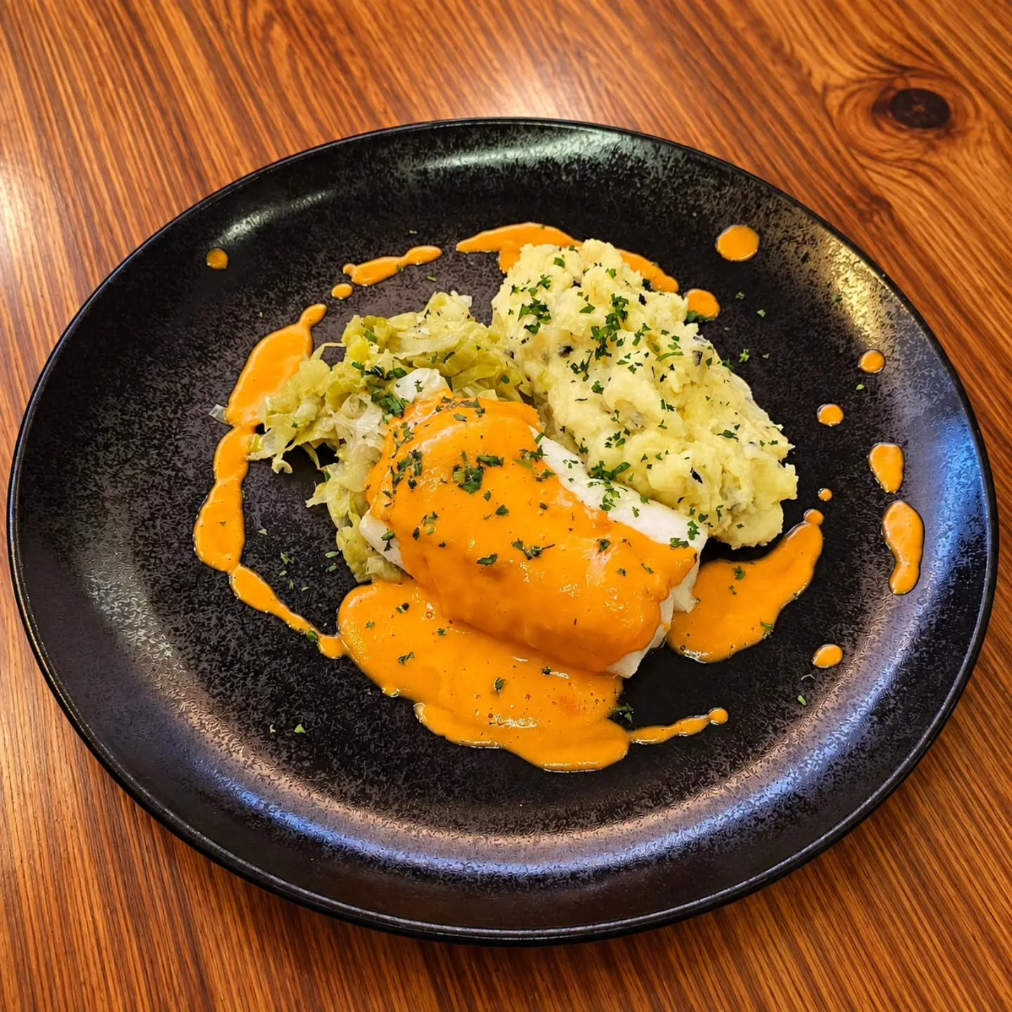 Suprême de cabillaud, sauce aux poivrons, écrasé de pdt aux olives, tombé de poireaux