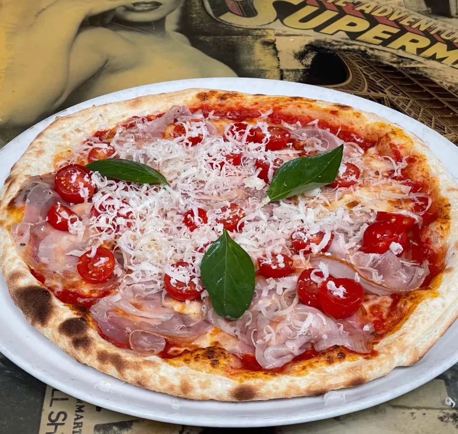 Pizza tomate, mozzarella, pancetta, tomates cerises, parmesan râpé, basilic