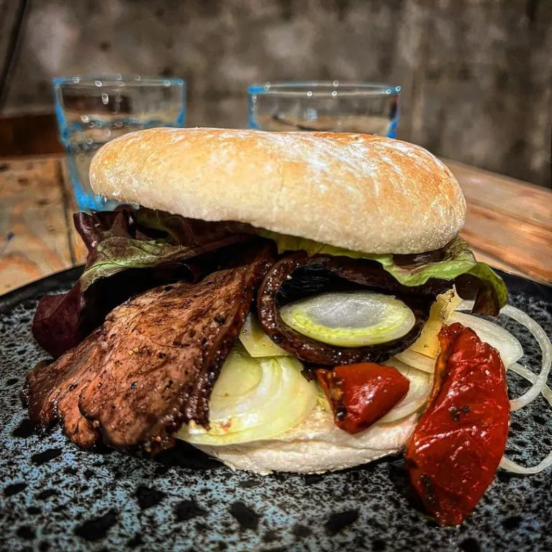 Paleron Beef burger, paleron de boeuf confit à l’ail noir en basse température, oignons, gruyère AOP et tomates servi avec frites maison