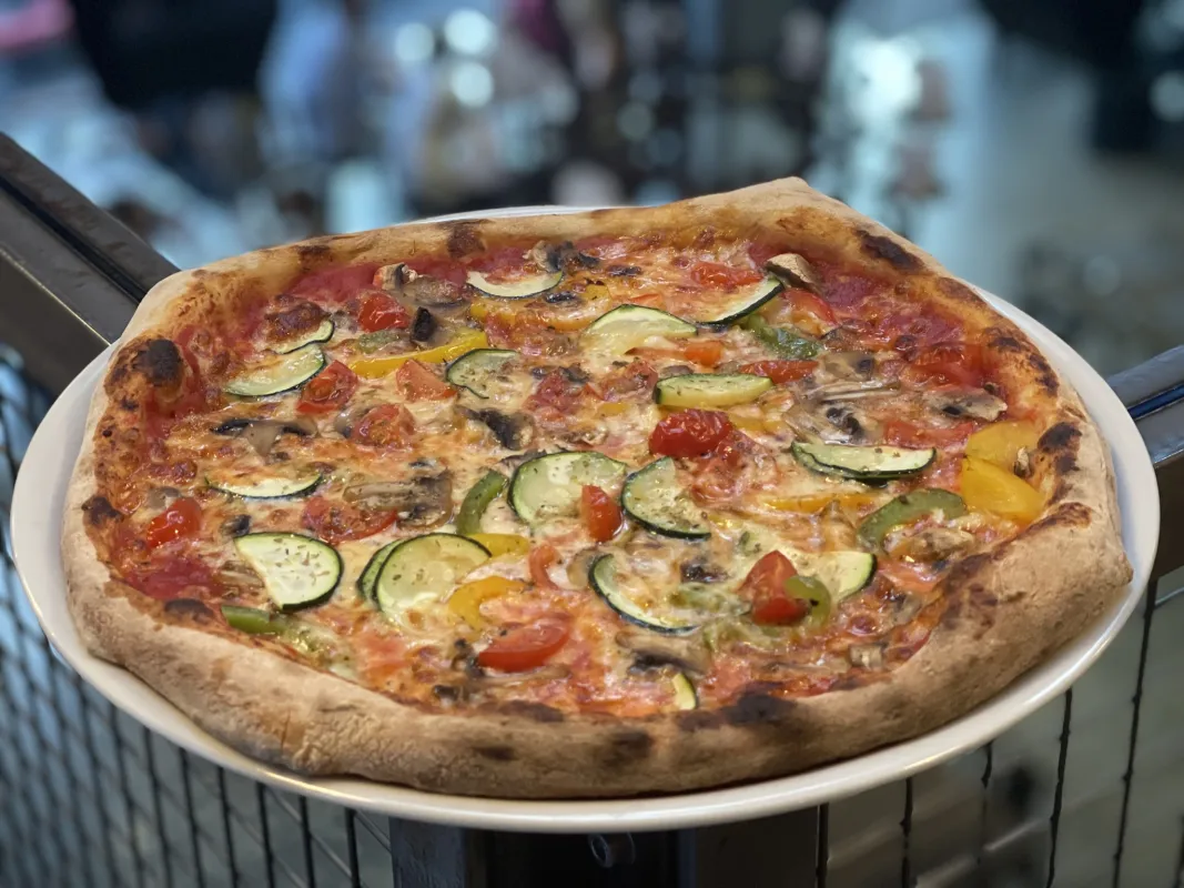 Pizza tomate, mozzarella, courgettes, poivrons, champignons, tomates cerises.