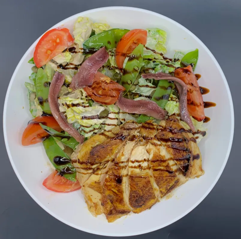 Salade César sucrine, tomate, anchois, câpre, suprême de poulet, croûton, sauce césar