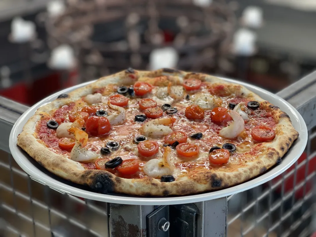 Pizza : tomate, mozzarella, gambas, tomates cerises, olives noires.