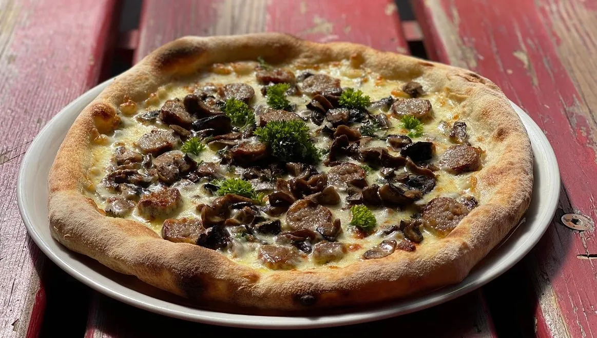 Pizza mozzarella, mélange de champignons, saucisse de Toulouse, persil