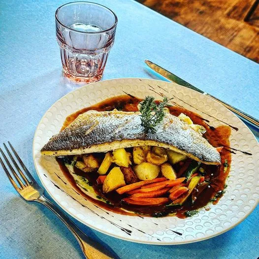 Filet de loup de Méditerranée à la plancha, sauce vin rouge acidulée au citron vert, pommes de terre grenailles rôties et légumes