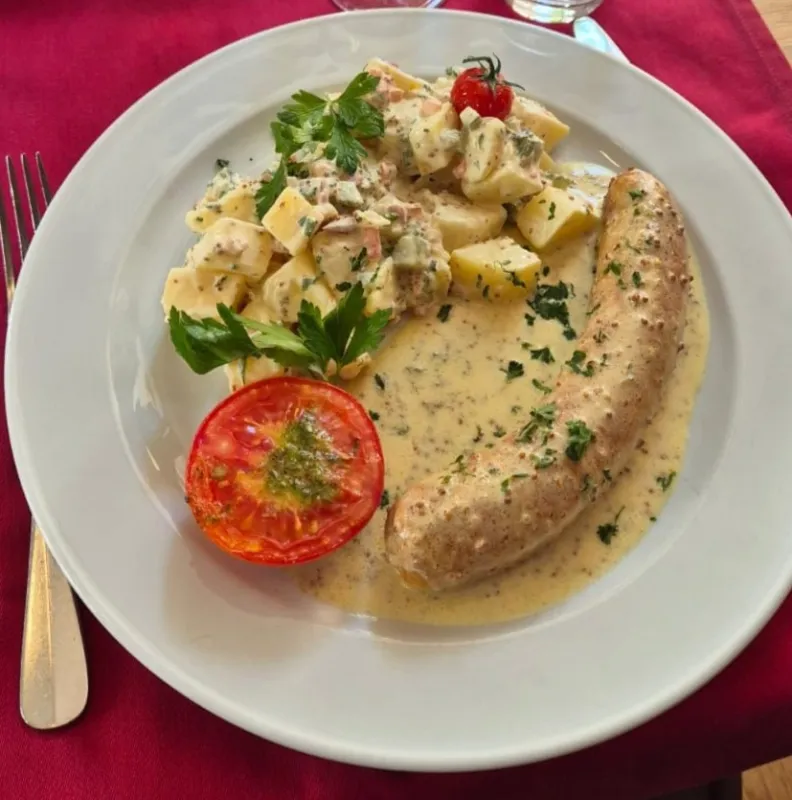 Saucisse de veau, sauce moutarde, salade de pomme de terre et tomate grillée