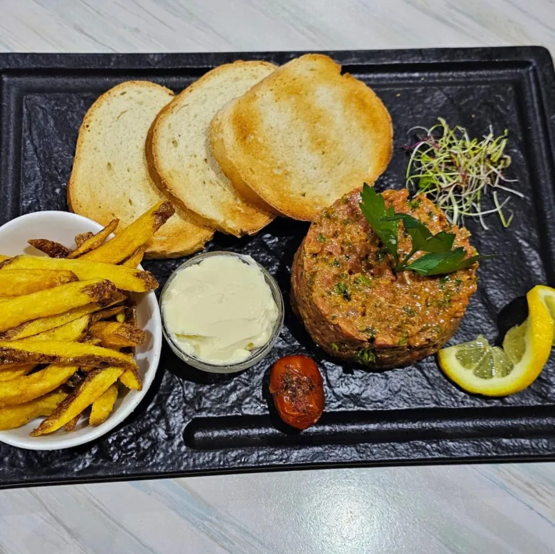 Tartare de bœuf (viande de chez Bellon), à la mode du Chef, pain grillé, frites maison et beurre