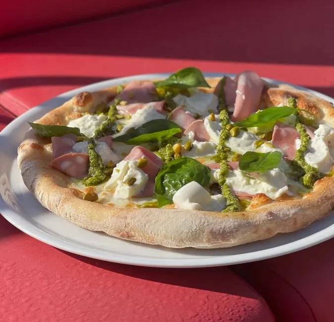 Pizza mozzarella, pesto de pistaches, mortadella, burratina, zestes de citrons, basilic frais