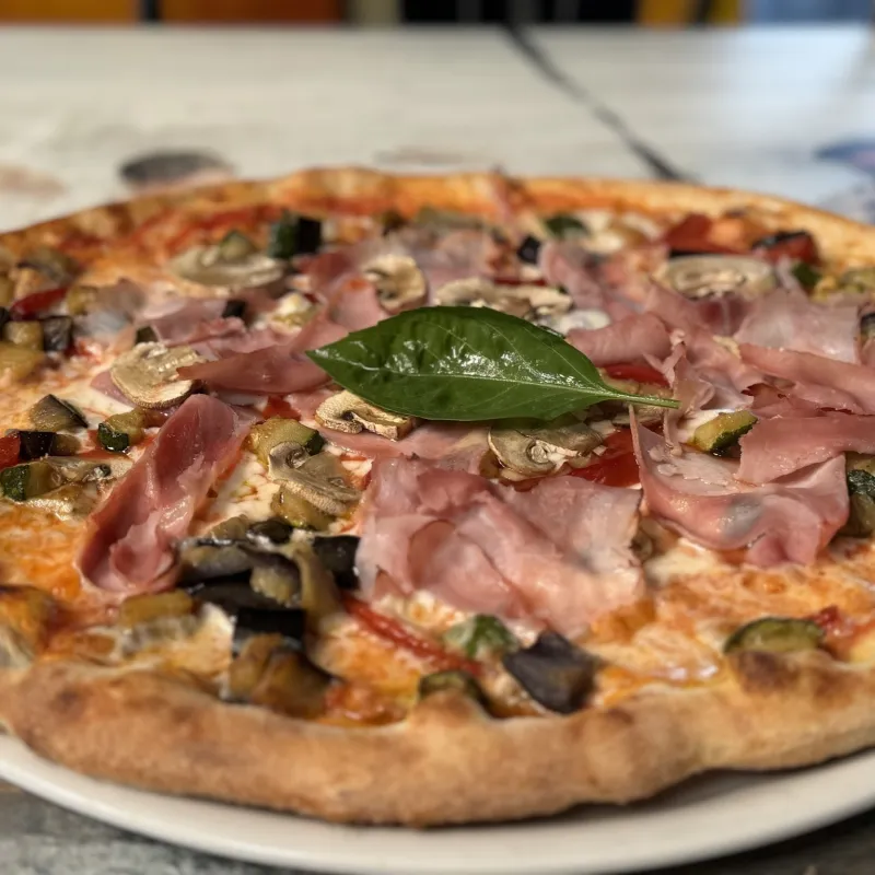 Pizza tomate, mozzarella, jambon, champignons, courgettes, poivrons, aubergines, origan