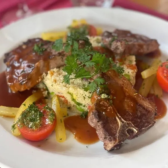 Côtes d'agneau grillées aux herbes, taboulé aux fèves et raisins noirs