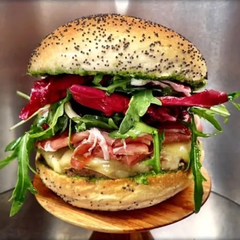 Burger le Mojo : Bun artisanal boulanger, steak Beefore, raclette Bagnes 98, pesto maison à l'ail des ours, jambon cru, duo de salade et balsamique