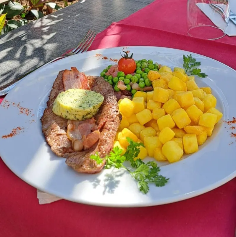 Steak chasseur au grill, beurre à l'estragon, pommes rissolées, petits pois aux lardons
