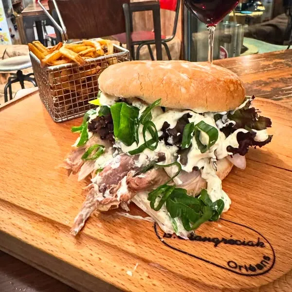 Le Burger Pascal à l’effilochée d’épaule de cabris de Sisteron, échalotes et fromage frais aux fines herbes servi avec frites maison